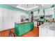 Bright kitchen featuring white cabinets, a large island with a wooden countertop, and hardwood floors at 9116 Woodridge Run Dr, Tampa, FL 33647