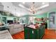 Open kitchen featuring a large green island, white cabinets, and views of the adjacent living area at 9116 Woodridge Run Dr, Tampa, FL 33647
