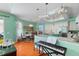 Open kitchen and dining area featuring a large island, hardwood floors, and elegant chandeliers at 9116 Woodridge Run Dr, Tampa, FL 33647