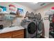 Convenient laundry room equipped with modern washer and dryer, storage, and a utility sink at 9116 Woodridge Run Dr, Tampa, FL 33647