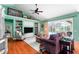 Cozy living room features vaulted ceilings, hardwood floors, built-in shelving, and sliding glass doors to the pool at 9116 Woodridge Run Dr, Tampa, FL 33647