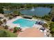 Aerial view of a beautiful community swimming pool, lakeside with adjacent playground and seating area at 9116 Woodridge Run Dr, Tampa, FL 33647