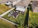 Aerial view of backyard showcasing a custom hardscape, meticulous landscape, and white vinyl fencing at 9334 Lemon Drop Loop, Sun City Center, FL 33573