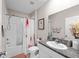 Bright bathroom featuring a granite countertop, bathtub with shower, and decorative floral shower curtain at 9334 Lemon Drop Loop, Sun City Center, FL 33573