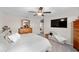 Bedroom featuring a TV, dresser with mirror, ceiling fan, window and bench at 9334 Lemon Drop Loop, Sun City Center, FL 33573