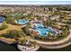 Overhead community pool image featuring a lounge area, splash pad, and mature landscaping at 9334 Lemon Drop Loop, Sun City Center, FL 33573