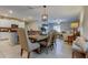 Open-concept dining area with a large wooden table, stylish lighting, and easy access to the kitchen at 9334 Lemon Drop Loop, Sun City Center, FL 33573
