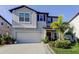 Two-story home with a well-maintained lawn, tropical landscaping, and a two-car garage at 9334 Lemon Drop Loop, Sun City Center, FL 33573