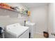 Well-equipped laundry room featuring a washer, dryer, and storage shelving at 9334 Lemon Drop Loop, Sun City Center, FL 33573