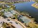 Lakeside aerial view of community tennis and basketball courts amidst lush landscaping at 9334 Lemon Drop Loop, Sun City Center, FL 33573