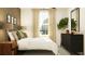 Light-filled bedroom featuring a large window, dresser, and plush bedding at 9437 Raised Tulip Ln, Land O Lakes, FL 34637