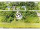 Aerial view of a home with a pool, solar panels, surrounded by lush greenery and other residential houses at 1857 N San Mateo Dr, North Port, FL 34288