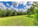 Lush green backyard with a serene canal view, providing a peaceful outdoor space at 1857 N San Mateo Dr, North Port, FL 34288