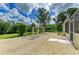 Expansive backyard with gravel, lush greenery, and a charming pergola, a serene outdoor space at 1857 N San Mateo Dr, North Port, FL 34288
