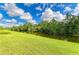 Scenic view of the tranquil backyard canal, bordered by lush greenery and a well-maintained lawn at 1857 N San Mateo Dr, North Port, FL 34288