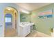 Bathroom features a vanity with ample counter space and storage, tile floor, and neutral walls at 1857 N San Mateo Dr, North Port, FL 34288