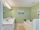 This bathroom has a soaking tub, tile floor, and a vanity with lots of light at 1857 N San Mateo Dr, North Port, FL 34288