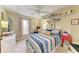Cozy bedroom featuring a striped bedspread, ceiling fan, and shelving with displayed decor at 1857 N San Mateo Dr, North Port, FL 34288