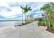 Picturesque waterfront walkway featuring lush landscaping, palm trees, and scenic lake views at 1857 N San Mateo Dr, North Port, FL 34288