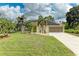 Beautiful front exterior of a well-maintained house with green lawn and mature palm trees at 1857 N San Mateo Dr, North Port, FL 34288