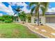 Charming home exterior with a well-manicured lawn, stepping stones, and lush landscaping at 1857 N San Mateo Dr, North Port, FL 34288