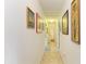 A hallway with tile floors leads past framed artwork to a bathroom at 1857 N San Mateo Dr, North Port, FL 34288