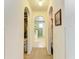 Hallway has arched doorways, neutral carpet and paint, and access to rooms and closets at 1857 N San Mateo Dr, North Port, FL 34288