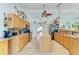 This spacious kitchen has natural wood cabinetry, modern appliances, an island, and tile flooring at 1857 N San Mateo Dr, North Port, FL 34288