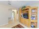Cozy living room featuring a wooden entertainment center and neutral tile flooring at 1857 N San Mateo Dr, North Port, FL 34288