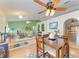 Inviting living room and dining area with archways, ceiling fans and wood flooring at 1857 N San Mateo Dr, North Port, FL 34288
