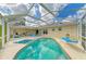 Backyard screened-in pool and spa area with lounge chairs and patio space at 1857 N San Mateo Dr, North Port, FL 34288