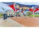 Community gathering place with colorful sunshades, comfortable seating, and various shops and restaurants in the background at 1857 N San Mateo Dr, North Port, FL 34288