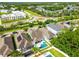 Aerial view showcasing a neighborhood with lush landscaping, a roundabout, and nearby amenities at 11307 Quiet Forest Dr, Tampa, FL 33635