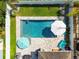 Aerial view of a luxurious pool area with patio umbrellas, comfortable seating, and well-maintained landscaping at 11307 Quiet Forest Dr, Tampa, FL 33635