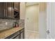 A convenient bar area with granite countertops, dark cabinetry, and a wine rack at 11307 Quiet Forest Dr, Tampa, FL 33635