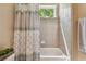The bathroom features a shower-tub with light grey tiling and a window to the backyard at 11307 Quiet Forest Dr, Tampa, FL 33635