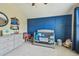Charming Bedroom featuring blue paneled wall, gray furniture, and plush toys at 11307 Quiet Forest Dr, Tampa, FL 33635