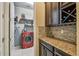 A laundry area with dark cabinets and granite countertops, with access to the laundry room at 11307 Quiet Forest Dr, Tampa, FL 33635