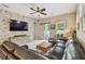 Open living area with a large television mounted above a cabinet and a comfortable, oversized leather sofa at 11307 Quiet Forest Dr, Tampa, FL 33635