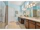 Bright main bathroom with dual sinks, a large vanity, and a walk-in shower with glass door at 11307 Quiet Forest Dr, Tampa, FL 33635
