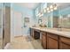 Bright bathroom with dual sinks, a large vanity, and a walk-in shower with a glass door at 11307 Quiet Forest Dr, Tampa, FL 33635