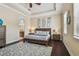 Comfortable main bedroom suite featuring a trey ceiling, wood floors, and a doorway leading to the main bath at 11307 Quiet Forest Dr, Tampa, FL 33635