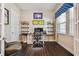 A comfortable office space with hardwood floors, built-in shelves, and natural light from the window at 11307 Quiet Forest Dr, Tampa, FL 33635