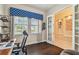 Bright office space with french doors leading to a sitting room, featuring hardwood floors and a large window at 11307 Quiet Forest Dr, Tampa, FL 33635