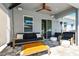 Covered patio with comfortable seating, fan, and views through sliding glass doors of pool and backyard at 11307 Quiet Forest Dr, Tampa, FL 33635