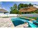 Outdoor living space with a sparkling pool, cozy seating, and a lush lawn, perfect for relaxation and enjoying the sunshine at 11307 Quiet Forest Dr, Tampa, FL 33635