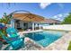 Backyard pool with patio, umbrella and plenty of seating for outdoor entertaining on a sunny day at 11307 Quiet Forest Dr, Tampa, FL 33635