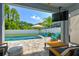 Inviting covered patio with a TV, a white fence, and beautiful pool area with outdoor seating at 11307 Quiet Forest Dr, Tampa, FL 33635