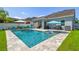Beautiful backyard showcasing a sparkling pool, lounge area, and a well-maintained lawn, perfect for outdoor relaxation and entertainment at 11307 Quiet Forest Dr, Tampa, FL 33635