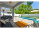 Inviting covered patio with comfortable seating area overlooking the sparkling pool and lush landscaping at 11307 Quiet Forest Dr, Tampa, FL 33635